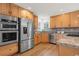 Bright kitchen featuring stainless steel appliances, wood cabinets, granite countertops, and hardwood flooring at 2330 Sandpiper Dr, Lafayette, CO 80026