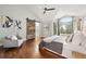 Vaulted ceiling bedroom with barn door to bath, gray walls, hardwood floors and neutral colored furniture at 9871 Indian Wells Dr, Lone Tree, CO 80124