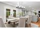 Bright dining room with gray table set, modern lighting and a view of outdoor patio and nature at 9871 Indian Wells Dr, Lone Tree, CO 80124