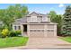 Two-story home with a three-car garage, brick accents, and a well-manicured lawn at 9871 Indian Wells Dr, Lone Tree, CO 80124