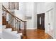 Elegant foyer with hardwood floors, grand staircase, and a stained wood front door at 9871 Indian Wells Dr, Lone Tree, CO 80124