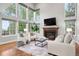 Cozy living room featuring a fireplace, large windows, and comfortable seating at 9871 Indian Wells Dr, Lone Tree, CO 80124