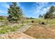 This backyard offers a fire pit, green grass, a garden, and a wooden deck at 15740 Sandtrap Way, Morrison, CO 80465