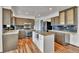 This kitchen features stainless steel appliances, light countertops, wooden floors, and a center island at 15740 Sandtrap Way, Morrison, CO 80465