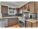 This kitchen features wood cabinets, stainless steel appliances, and dark backsplash at 15740 Sandtrap Way, Morrison, CO 80465
