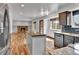 This open concept living room and kitchen features a stone fireplace and stainless steel refrigerator at 15740 Sandtrap Way, Morrison, CO 80465