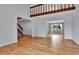 Spacious living room with hardwood floors, leading to a staircase and dining area with large windows at 15740 Sandtrap Way, Morrison, CO 80465
