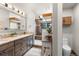 Bathroom featuring granite counters, wooden cabinets, and a walk-in shower with natural lighting at 23785 Currant Dr, Golden, CO 80401