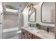 Bathroom with a double vanity, granite countertops, and a skylight above the tub at 23785 Currant Dr, Golden, CO 80401