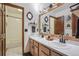 Bathroom with double sinks, wood-framed mirror, and a separate tub/shower room at 7954 S Franklin Ct, Centennial, CO 80122