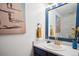 Charming powder room features a unique blue mirror frame, modern lighting, and a stylish accent wall at 7954 S Franklin Ct, Centennial, CO 80122