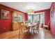 Elegant dining room with bright red walls, hardwood floors, bay window, and a classic china cabinet at 7954 S Franklin Ct, Centennial, CO 80122