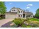 Charming two-story home with a well-manicured front yard, colorful flowers, and a covered front porch seating area at 7954 S Franklin Ct, Centennial, CO 80122