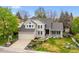 Charming two-story home featuring a well-manicured front yard with mature trees, a garden, and a two-car garage at 7954 S Franklin Ct, Centennial, CO 80122