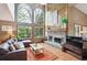Open living area with large windows, fireplace, hardwood floors, and a sectional couch creating a cozy and inviting space at 7954 S Franklin Ct, Centennial, CO 80122