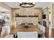 Bright dining room with a stacked stone fireplace, hardwood floors, and modern lighting fixture at 16541 W 48Th Ln, Golden, CO 80403