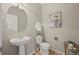 Well-lit powder room features a pedestal sink, oval mirror, and charming decor at 16404 E 117Th Ave, Commerce City, CO 80022