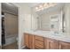 Bathroom with double sinks, wooden cabinets, and shower-tub combo at 16404 E 117Th Ave, Commerce City, CO 80022