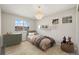 Bright bedroom featuring a charming chandelier, large windows, and neutral decor at 16404 E 117Th Ave, Commerce City, CO 80022