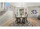 Well-lit dining area with wood table, and modern light fixture near staircase and large windows at 16404 E 117Th Ave, Commerce City, CO 80022