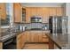 Bright kitchen features natural wood cabinets, granite counters, stainless appliances, and tiled backsplash at 16404 E 117Th Ave, Commerce City, CO 80022