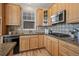 Bright kitchen features natural wood cabinets, granite counters, stainless appliances, and tiled backsplash at 16404 E 117Th Ave, Commerce City, CO 80022
