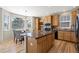 Kitchen island with natural wood cabinets, stainless steel appliances, and granite counters at 16404 E 117Th Ave, Commerce City, CO 80022
