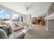 Bright and airy living room featuring large windows, plush seating, and an open floor plan connecting to the kitchen and dining area at 16404 E 117Th Ave, Commerce City, CO 80022