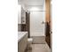 Modern bathroom with shower featuring a curtain, white tile, and wood accents, complemented by a sleek sink at 2627 W 40Th Ave, Denver, CO 80211