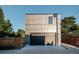 Modern home exterior featuring a dark garage door, gray facade, and lush green landscaping at 2627 W 40Th Ave, Denver, CO 80211