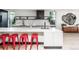 Modern kitchen with a white island, red stools, open shelving, marble backsplash and hardwood floors at 2627 W 40Th Ave, Denver, CO 80211