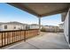 Covered patio with wood railing overlooks the backyard and neighboring homes at 4128 Castle Vista Ln, Castle Rock, CO 80104