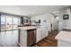 Open concept kitchen flowing into the living room, stainless steel appliances, white cabinets, and quartz countertops at 4128 Castle Vista Ln, Castle Rock, CO 80104