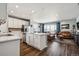 Spacious kitchen flowing into the living room, stainless steel appliances, white cabinets, and hardwood floors at 4128 Castle Vista Ln, Castle Rock, CO 80104