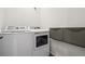 The laundry room has a white washer and dryer with grey accents at 4128 Castle Vista Ln, Castle Rock, CO 80104