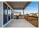 Covered patio area featuring a grill, wood railing, and backyard views at 4128 Castle Vista Ln, Castle Rock, CO 80104