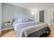 Bedroom with wood floors, a window, a floor lamp, and a bed with grey, white, and pink linens at 14252 E Radcliff Cir, Aurora, CO 80015