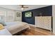 Main bedroom with hardwood floors, ceiling fan, and a stylish accent wall at 14252 E Radcliff Cir, Aurora, CO 80015