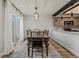 Dining area with access to patio, a modern light fixture, brick wall, and view into the kitchen at 14252 E Radcliff Cir, Aurora, CO 80015