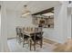 Open dining area featuring a modern light fixture, brick wall, and view into the kitchen at 14252 E Radcliff Cir, Aurora, CO 80015