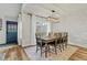 Bright dining room featuring a rustic wood table, modern lighting, and white-painted brick wall at 14252 E Radcliff Cir, Aurora, CO 80015