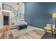 Inviting living area with a staircase, blue accent wall, modern furniture, and natural light at 14252 E Radcliff Cir, Aurora, CO 80015