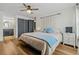 Bright main bedroom features wood floors, a ceiling fan, a macrame wall decoration, and access to the ensuite bath at 14252 E Radcliff Cir, Aurora, CO 80015