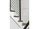 Modern staircase with wooden treads and black metal railing enhances the home's architectural appeal at 14252 E Radcliff Cir, Aurora, CO 80015