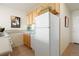 View of the kitchen area with light wood cabinetry, white refrigerator, and tile flooring at 909 N Logan St # 10C, Denver, CO 80203