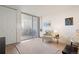 Bright living room with a neutral armchair, art, and a sliding glass door to a balcony at 909 N Logan St # 10C, Denver, CO 80203