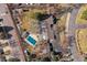 Aerial view of property featuring a pool, pool house, lush landscaping, and large home with an extended sunroom at 7382 W Stanford Ave, Littleton, CO 80123