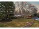 A serene backyard features a brick retaining wall, lush lawn, and a glimpse of the inviting blue pool at 7382 W Stanford Ave, Littleton, CO 80123