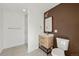 Modern bathroom featuring a walk-in shower and vanity with a wood-grain finish and brown accent wall at 7382 W Stanford Ave, Littleton, CO 80123