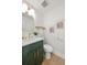 Stylish bathroom with a green vanity, modern fixtures, and decorative wallpaper at 7382 W Stanford Ave, Littleton, CO 80123
